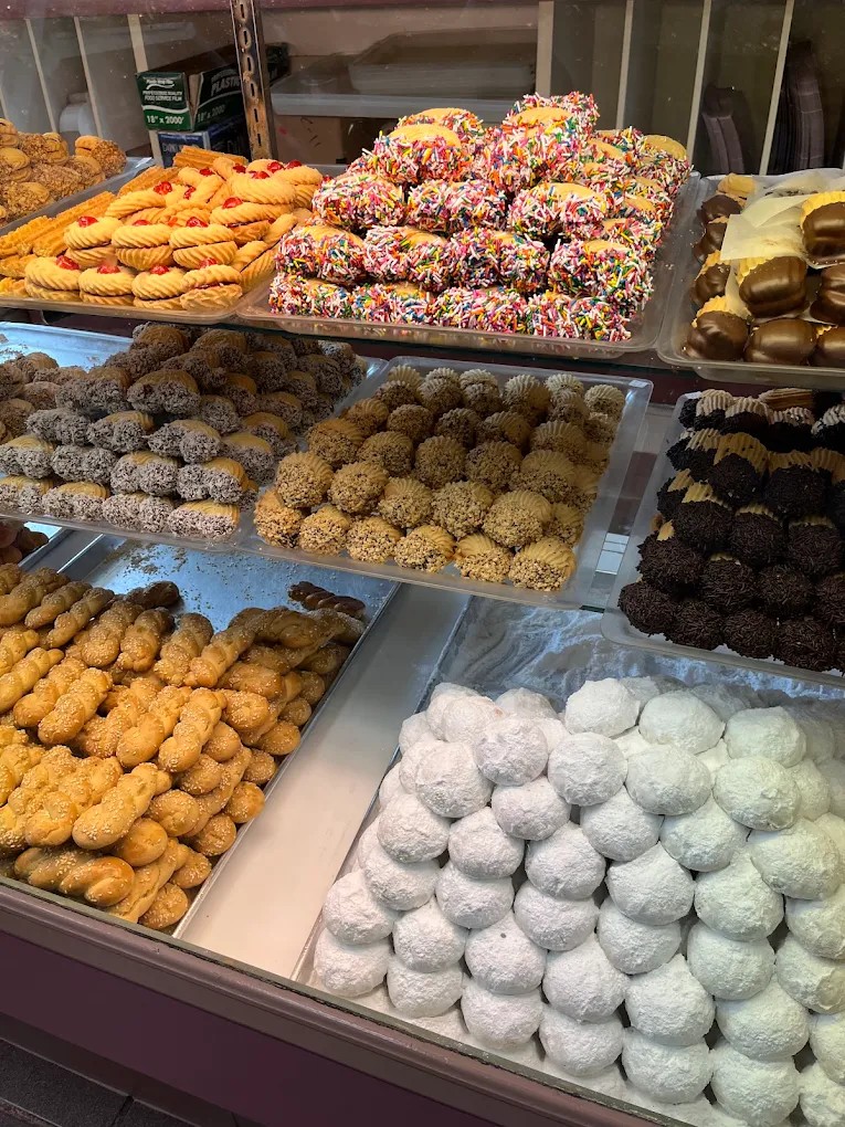 Rows of assorted cookies with cherries, sprinkles, chocolate, and coconut