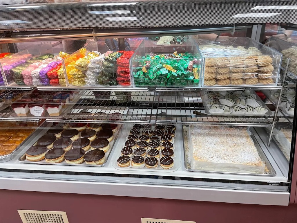 Candies, dessert cups, baklava, and chocolate pastries in the Elite Bakery case