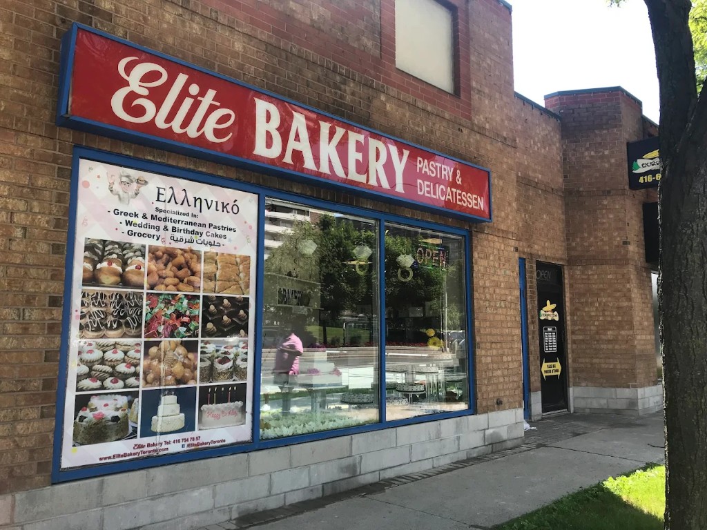 Elite Bakery storefront on Kennedy Road with red Elite Bakery sign and pastry posters